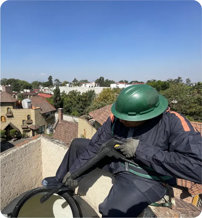 Técnico realiza desinfección a tinaco durante el lavado de cisternas y tinacos en Cuauhtémoc