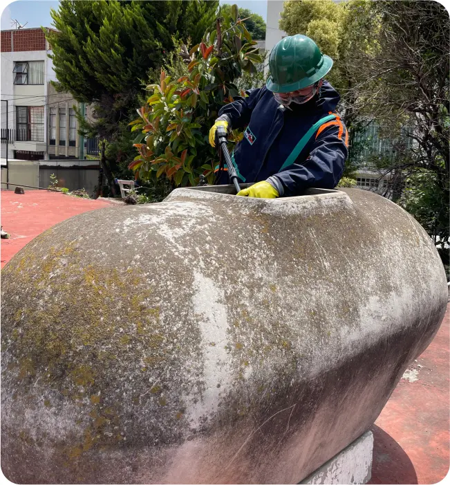 Técnico enjuaga un tinaco de asbesto durante el lavado de cisternas y tinacos en Cuauhtémoc