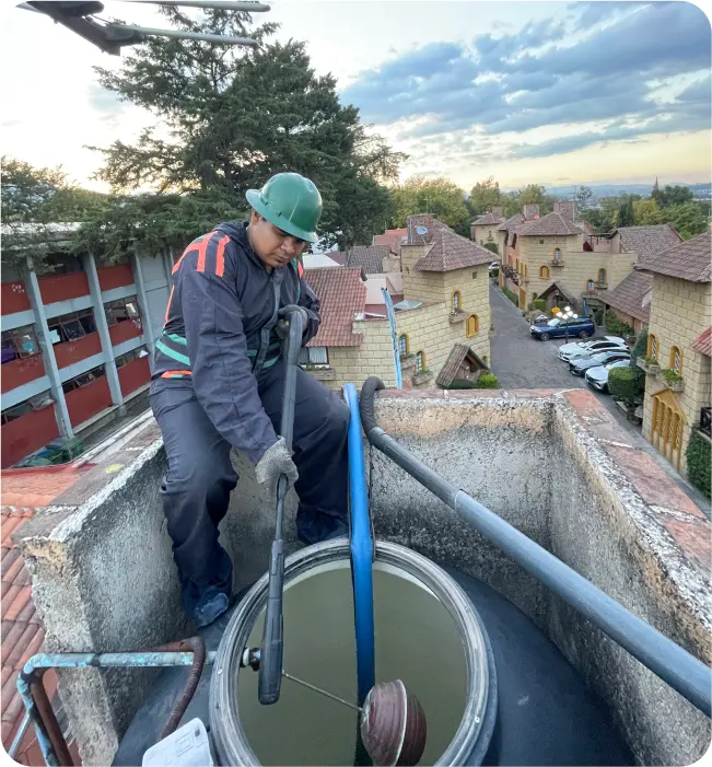 Técnico enjuaga un tinaco sin ingresar en el durante el lavado de tinacos y cisternas en Milpa Alta