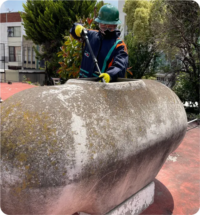 Técnico realiza una desinfección a un tinaco de asbesto durante la limpieza de tinacos y cisternas en Milpa Alta