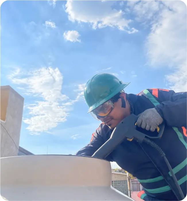 Técnico realiza el enjuague a un tinaco durante la limpieza de cisternas y tinacos en Naucalpan