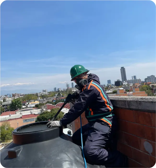 Operador realiza un enjuague durante el lavado de tinacos en Zumpango